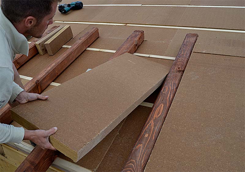 Wood fibre board installation on roof s beams